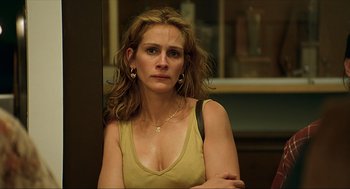 Movie still from “Erin Brockovich” (2000), directed by Steven Soderbergh – A woman in a yellow shirt is looking at the camera; Close Up shot, High angle