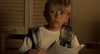 Movie still from “Erin Brockovich” (2000), directed by Steven Soderbergh – A young boy is holding a piece of paper; Close Up shot, High angle
