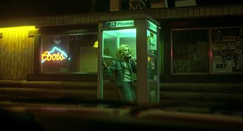 Movie still from “Erin Brockovich” (2000), directed by Steven Soderbergh – A woman standing in front of a phone booth on a street; Wide shot, Low angle