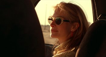 Movie still from “Erin Brockovich” (2000), directed by Steven Soderbergh – A woman wearing sunglasses sitting in a car; Close Up shot, Low angle