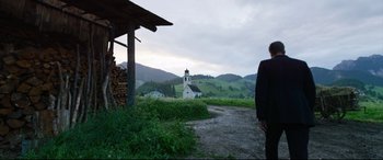 Movie still from “A Hidden Life” (2019), directed by Terrence Malick – A man standing in front of a white church; Wide shot, Low angle