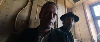 Movie still from “A Hidden Life” (2019), directed by Terrence Malick – A man in a suit and a man in a hat; Close Up shot, Low angle