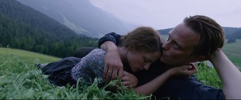 Movie still from “A Hidden Life” (2019), directed by Terrence Malick – A man and a woman laying on the ground in a field; Medium shot, High angle