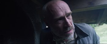 Movie still from “A Hidden Life” (2019), directed by Terrence Malick – A man with a gray beard is sitting in a car; Close Up shot, Low angle