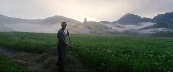 Movie still from “A Hidden Life” (2019), directed by Terrence Malick – A man standing in the middle of an open field; Wide shot, Low angle