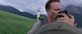 Movie still from “A Hidden Life” (2019), directed by Terrence Malick – A man standing in front of a building on top of a hill; Close Up shot, Low angle
