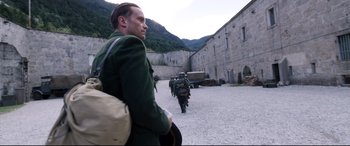 Movie still from “A Hidden Life” (2019), directed by Terrence Malick – A group of men walking down a street; Medium shot, Over the shoulder angle