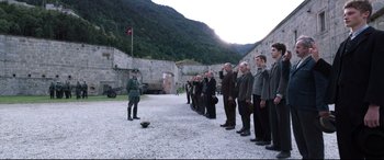 Movie still from “A Hidden Life” (2019), directed by Terrence Malick – A group of men standing next to each other in a courtyard; Extreme Wide shot, High angle