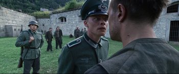 Movie still from “A Hidden Life” (2019), directed by Terrence Malick – A man in a uniform talking to another man in a uniform; Medium shot, Over the shoulder angle