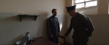 Movie still from “A Hidden Life” (2019), directed by Terrence Malick – A man in a uniform standing next to another man in a uniform; Medium shot, Over the shoulder angle