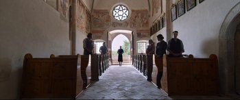 Movie still from “A Hidden Life” (2019), directed by Terrence Malick – A group of people standing inside of a building; Extreme Wide shot, Low angle