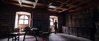 Movie still from “A Hidden Life” (2019), directed by Terrence Malick – A man standing in a room with a lot of books; Wide shot, Low angle