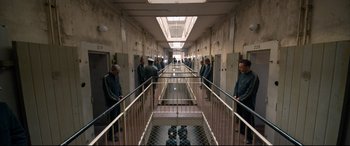 Movie still from “A Hidden Life” (2019), directed by Terrence Malick – A group of men standing in a hallway next to a railing; Extreme Wide shot, High angle