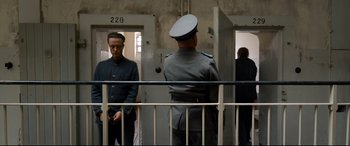 Movie still from “A Hidden Life” (2019), directed by Terrence Malick – Two men standing in front of each other in front of a door way; Medium shot, Over the shoulder angle