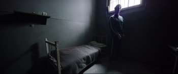 Movie still from “A Hidden Life” (2019), directed by Terrence Malick – A man standing next to a bed in a room; Wide shot, High angle