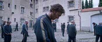 Movie still from “A Hidden Life” (2019), directed by Terrence Malick – A man is standing in front of a group of people; Medium shot, Over the shoulder angle