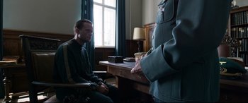 Movie still from “A Hidden Life” (2019), directed by Terrence Malick – A man sitting in front of another man in a uniform; Medium shot, Over the shoulder angle