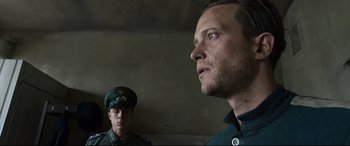 Movie still from “A Hidden Life” (2019), directed by Terrence Malick – A man in a military uniform looking into a mirror; Close Up shot, Over the shoulder angle