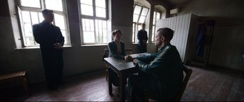 Movie still from “A Hidden Life” (2019), directed by Terrence Malick – A man and a woman sitting at a wooden table; Wide shot, Over the shoulder angle