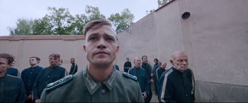 Movie still from “A Hidden Life” (2019), directed by Terrence Malick – A group of men standing next to each other in uniforms; Medium shot, Low angle