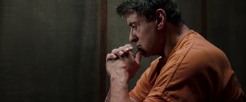 Movie still from “Escape Plan” (2013), directed by Mikael Håfström – A person with his hands clasped together; Close Up shot, Low angle