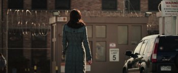 Movie still from “Escape Plan” (2013), directed by Mikael Håfström – A woman is walking down the street wearing a long coat; Wide shot, Over the shoulder angle