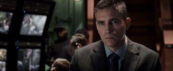 Movie still from “Escape Plan” (2013), directed by Mikael Håfström – A man wearing a suit and tie in front of a group of people; Close Up shot, Over the shoulder angle