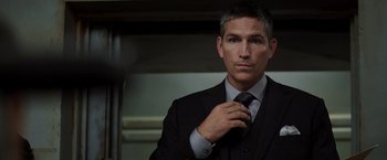 Movie still from “Escape Plan” (2013), directed by Mikael Håfström – A man in a suit adjusting his neck tie; Close Up shot, Over the shoulder angle