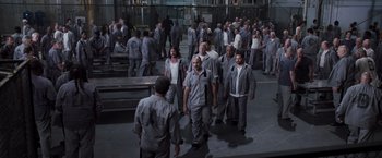 Movie still from “Escape Plan” (2013), directed by Mikael Håfström – A large group of people are in a warehouse; Wide shot, High angle