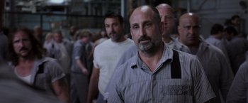 Movie still from “Escape Plan” (2013), directed by Mikael Håfström – A group of men standing next to each other in a line; Close Up shot, Over the shoulder angle