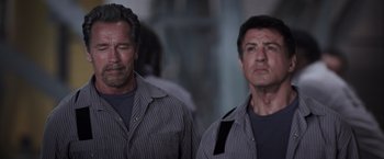 Movie still from “Escape Plan” (2013), directed by Mikael Håfström – A couple of men standing next to each other; Close Up shot, Low angle