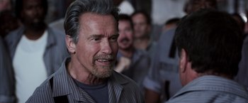 Movie still from “Escape Plan” (2013), directed by Mikael Håfström – An older man with gray hair and a beard; Close Up shot, Over the shoulder angle