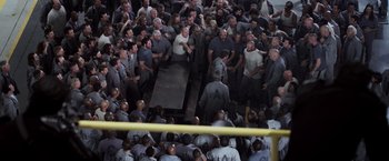 Movie still from “Escape Plan” (2013), directed by Mikael Håfström – A group of men standing next to each other in a room; Wide shot, High angle