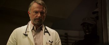 Movie still from “Escape Plan” (2013), directed by Mikael Håfström – A man with a stethoscope around his neck; Close Up shot, Low angle