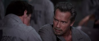 Movie still from “Escape Plan” (2013), directed by Mikael Håfström – An older man with gray hair and a mustache; Close Up shot, Over the shoulder angle