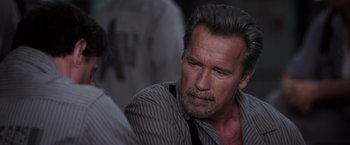 Movie still from “Escape Plan” (2013), directed by Mikael Håfström – An older man wearing a striped shirt and a tie; Close Up shot, Over the shoulder angle