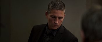 Movie still from “Escape Plan” (2013), directed by Mikael Håfström – A man in a black suit and a black tie; Close Up shot, Low angle