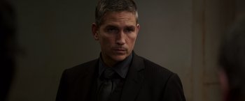 Movie still from “Escape Plan” (2013), directed by Mikael Håfström – A person wearing a suit and tie; Close Up shot, Low angle