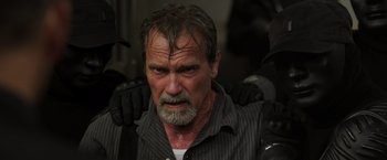 Movie still from “Escape Plan” (2013), directed by Mikael Håfström – An older man with a beard and a mustache; Close Up shot, Low angle