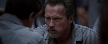 Movie still from “Escape Plan” (2013), directed by Mikael Håfström – An older man with a beard and a mustache; Close Up shot, Over the shoulder angle