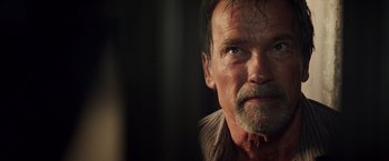 Movie still from “Escape Plan” (2013), directed by Mikael Håfström – An older man with a goatee looking into the distance; Close Up shot, Over the shoulder angle