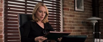 Movie still from “Escape Plan” (2013), directed by Mikael Håfström – A woman sitting in a chair looking at a tablet; Close Up shot, Low angle