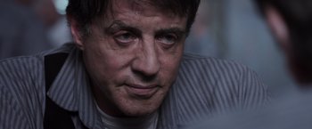 Movie still from “Escape Plan” (2013), directed by Mikael Håfström – A man's face in a dark room; Close Up shot, Low angle