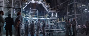 Movie still from “Escape Plan” (2013), directed by Mikael Håfström – A group of people standing around in a room; Extreme Wide shot, High angle