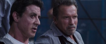 Movie still from “Escape Plan” (2013), directed by Mikael Håfström – A man with a beard and mustache and a man with a beard and mustache; Close Up shot, Over the shoulder angle