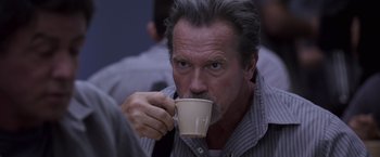 Movie still from “Escape Plan” (2013), directed by Mikael Håfström – A person drinking a cup of coffee; Close Up shot, Over the shoulder angle