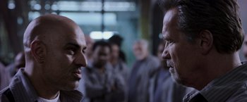 Movie still from “Escape Plan” (2013), directed by Mikael Håfström – A group of people standing in front of each other in a room; Close Up shot, Over the shoulder angle