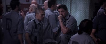 Movie still from “Escape Plan” (2013), directed by Mikael Håfström – A man in a jail cell with another man in a jail cell; Medium shot, Over the shoulder angle