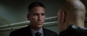 Movie still from “Escape Plan” (2013), directed by Mikael Håfström – A man in a suit and tie looking at another man in a suit and tie; Close Up shot, Over the shoulder angle