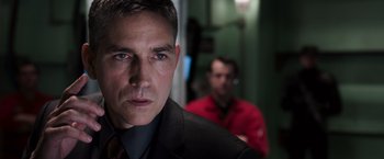 Movie still from “Escape Plan” (2013), directed by Mikael Håfström – A person wearing a suit and tie; Close Up shot, Over the shoulder angle